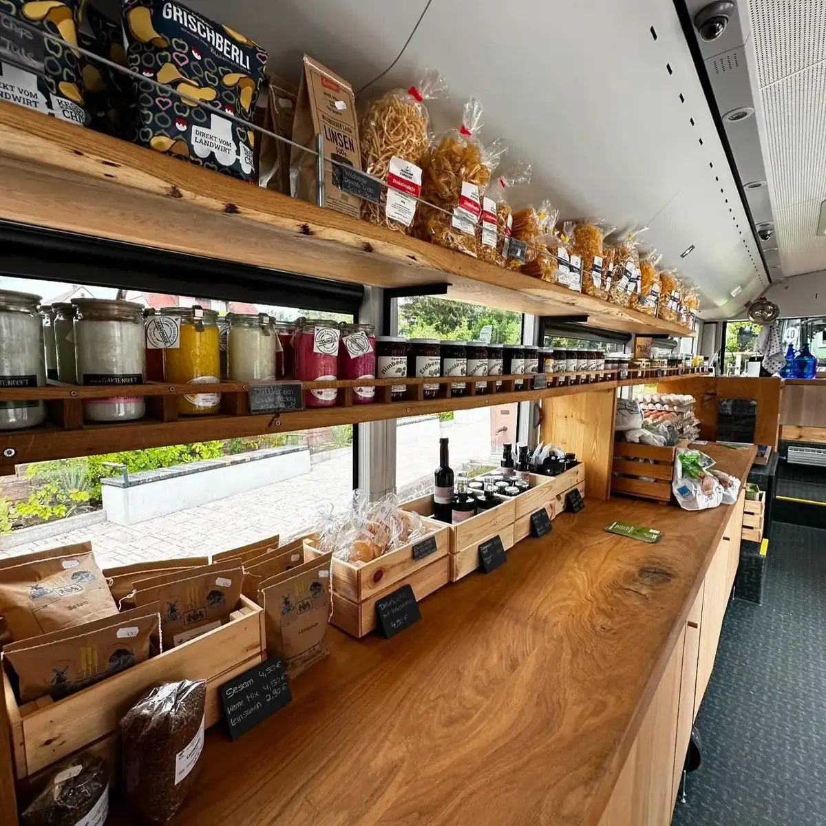 Holzregale im Hofbus mit Gläsern und Flaschen