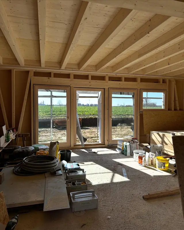 Heller Innenraum aus Holz mit großen Fenstern