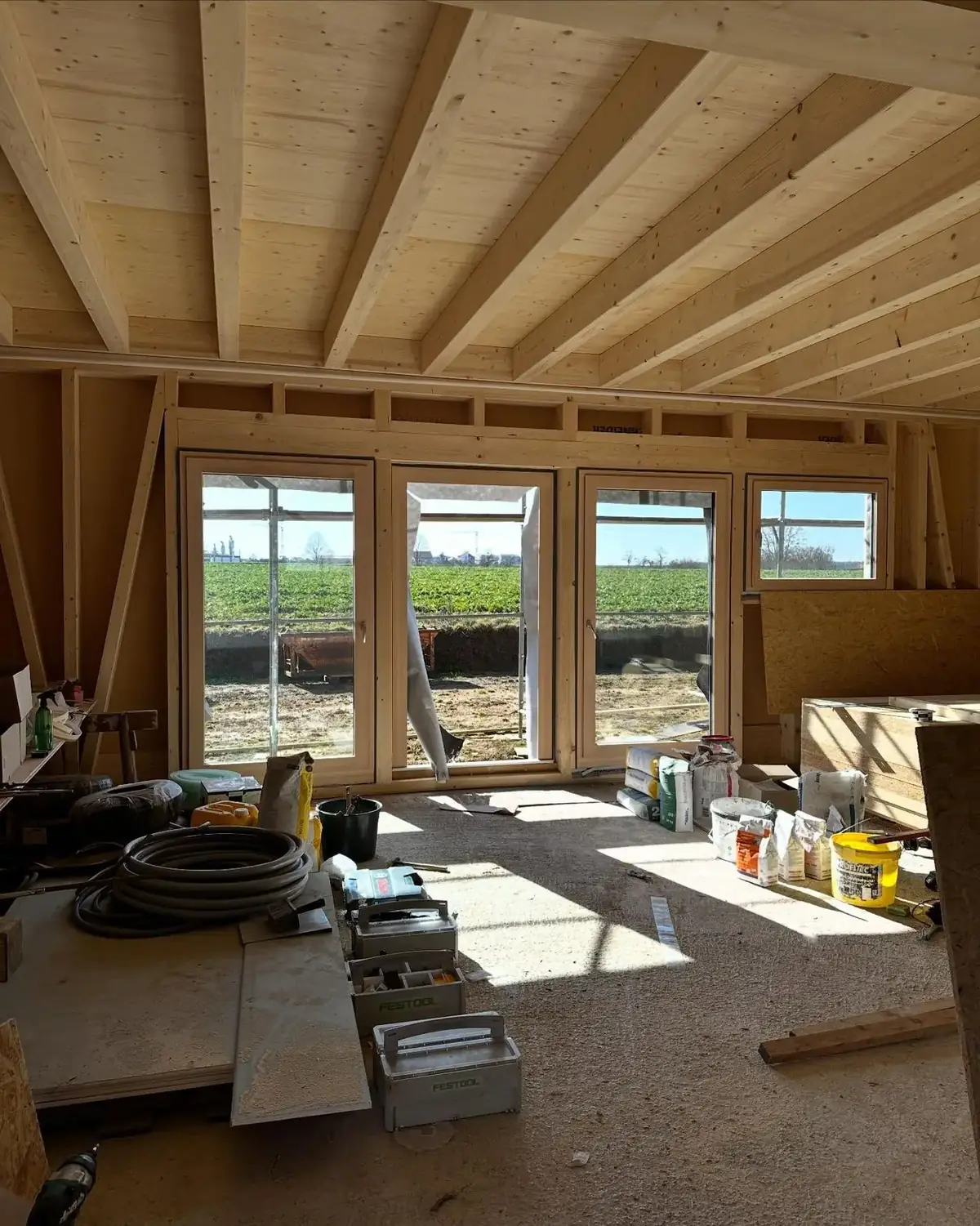 Heller Innenraum aus Holz mit großen Fenstern