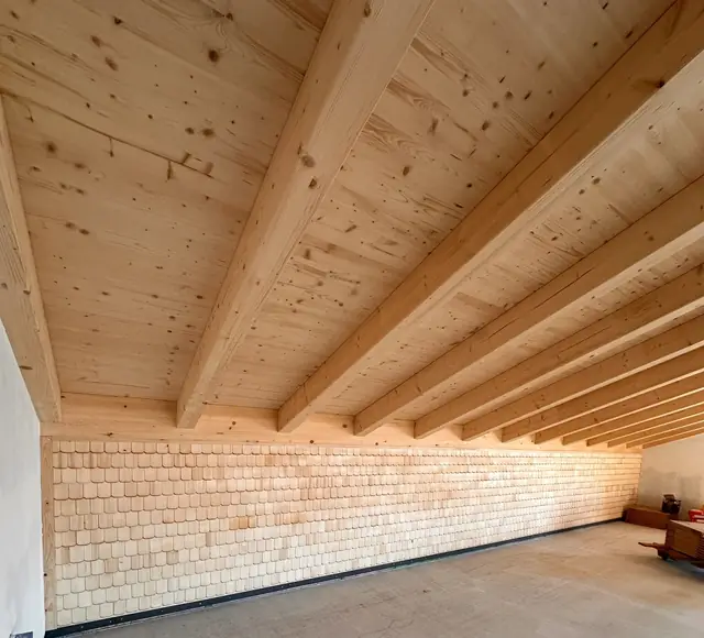 Lange Wand aus hellen Holzschindeln